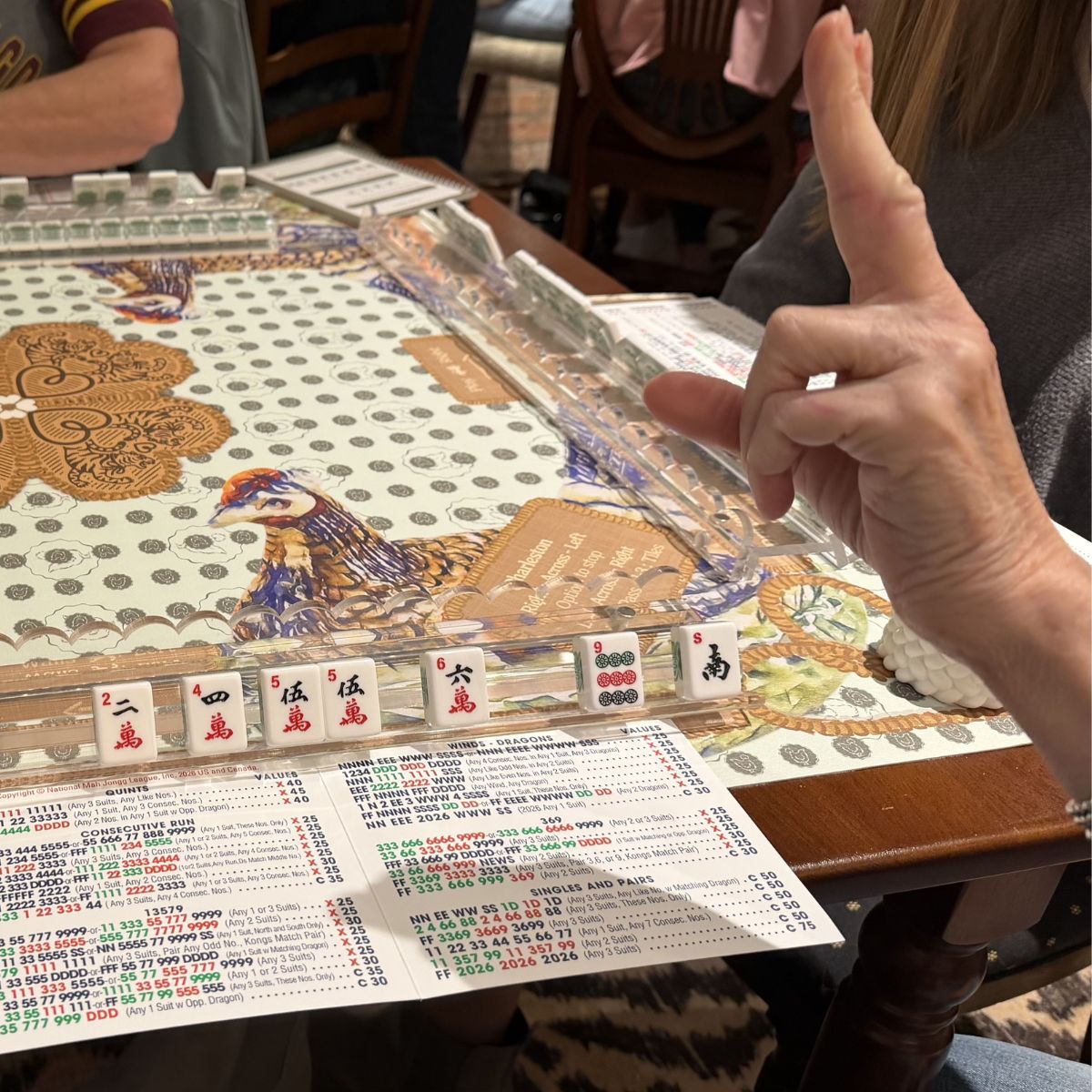Close-up of a person playing Mahjong with a detailed game board and tiles at The Pepper Pot in Barrington. IL 