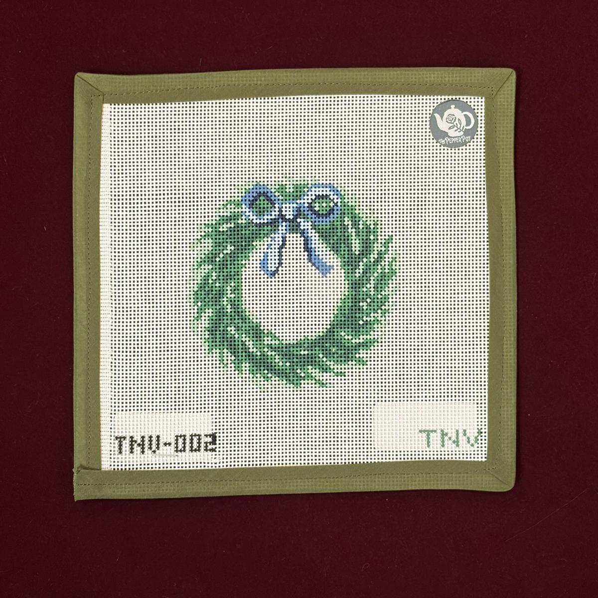 Needlepoint Canvas wreath design on fabric with green border. 