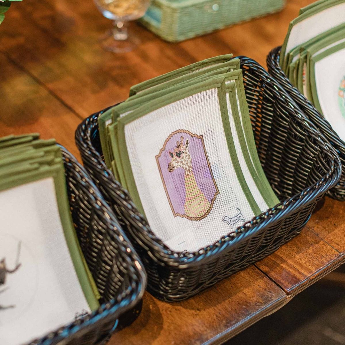 Needlepoint canvas options in a wicker basket for experts and beginner needlepoint stitchers at The Pepper Pot in Barrington, IL