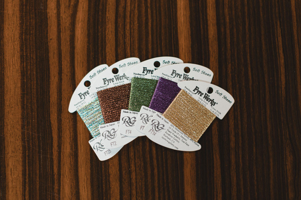 Set of color swatch cards with various textures on a wooden surface from Fyre Werks fibers.  | The Pepper Pot Barrington, IL 