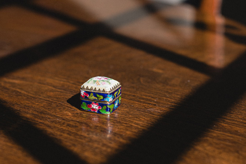 Colorful hinged needlepoint box on a wooden surface.  | The Pepper Pot Barrington, IL 