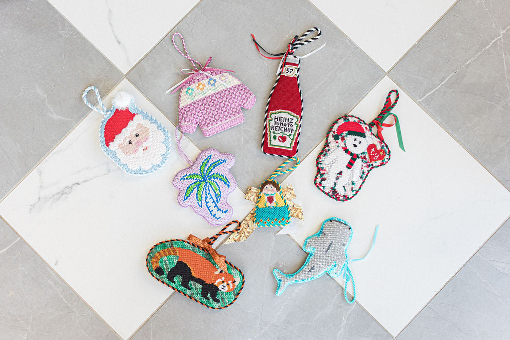 Colorful needlepoint ornaments on a tile surface.  | The Pepper Pot Barrington, IL 