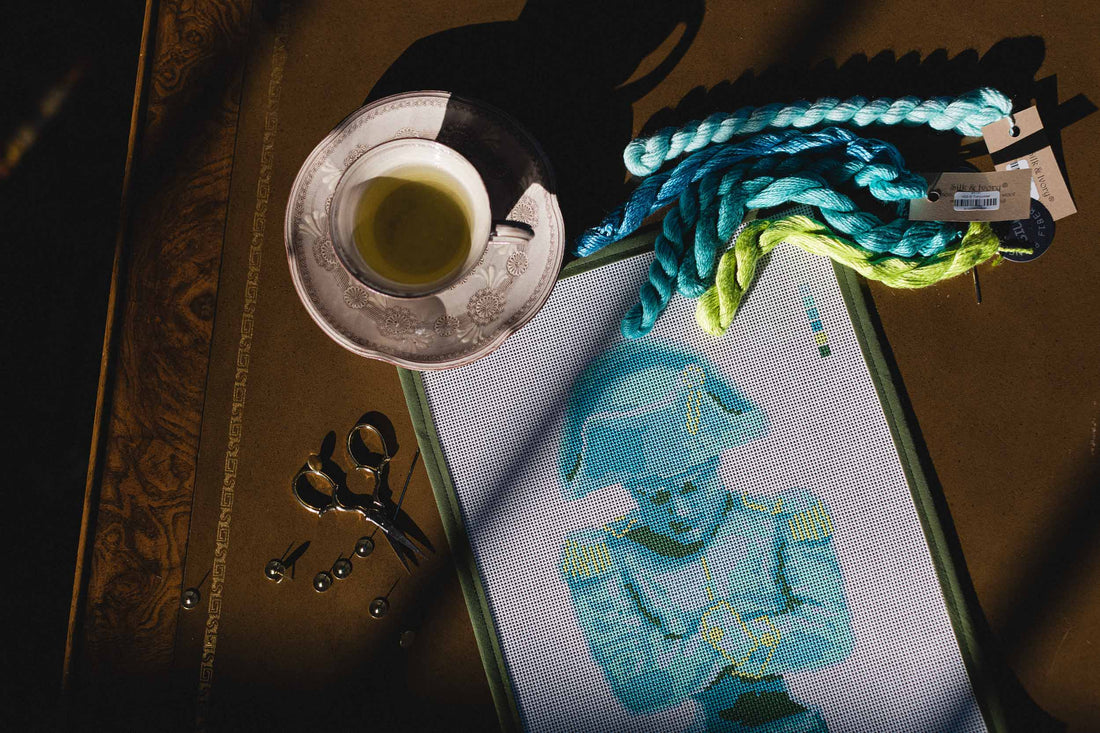 Cup of tea with embroidery hoop and thread on a wooden surface. | The Pepper Pot Barrington, IL 