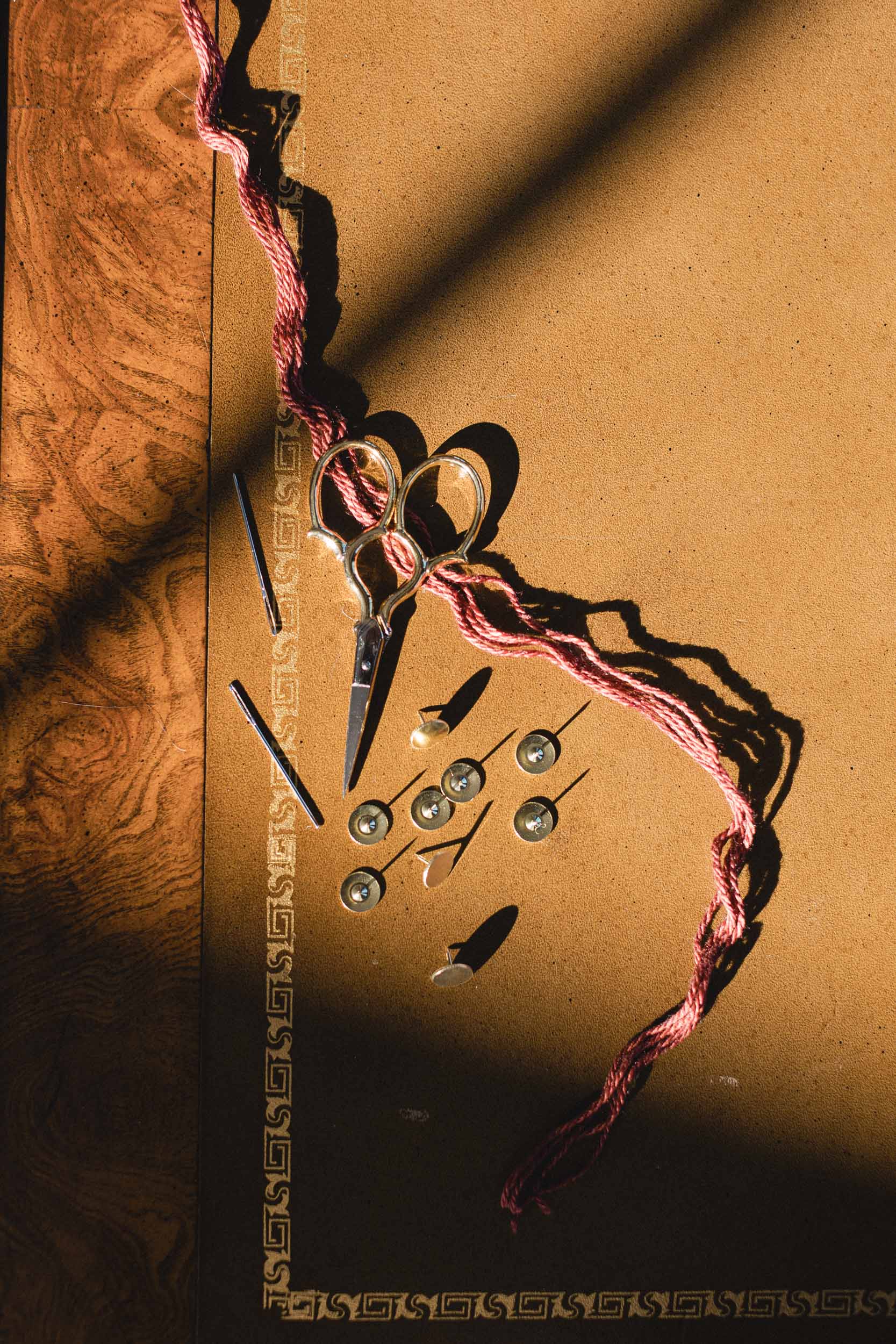 Scissors and needlepoint materials on a textured brown surface