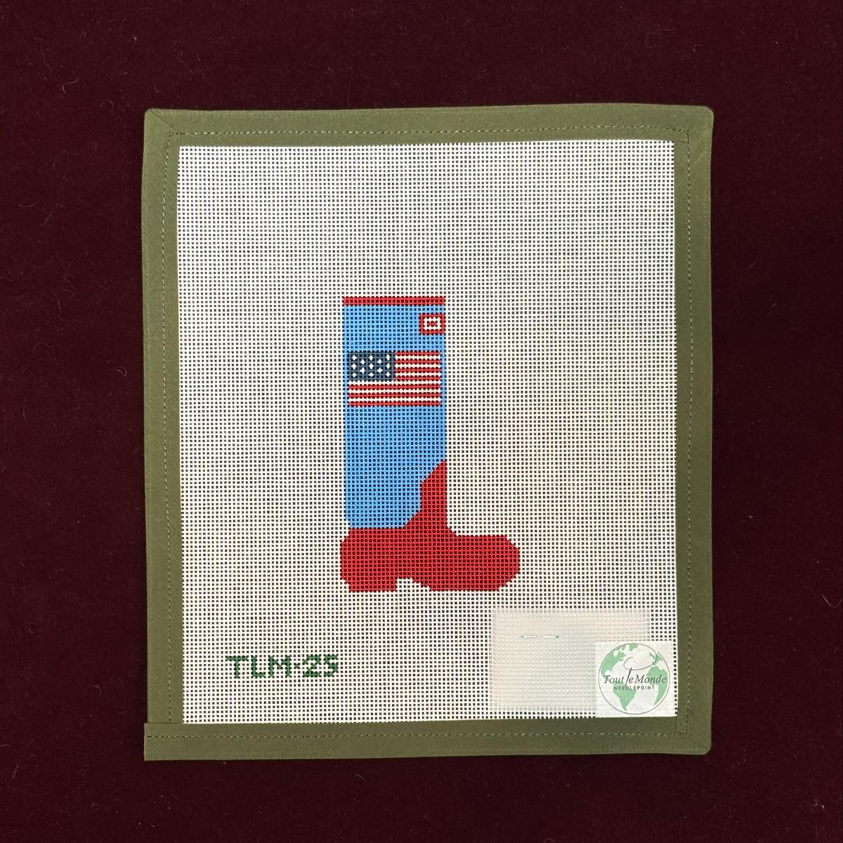 Needlepoint canvas design of a blue and red rain boot with an American flag on a white background.