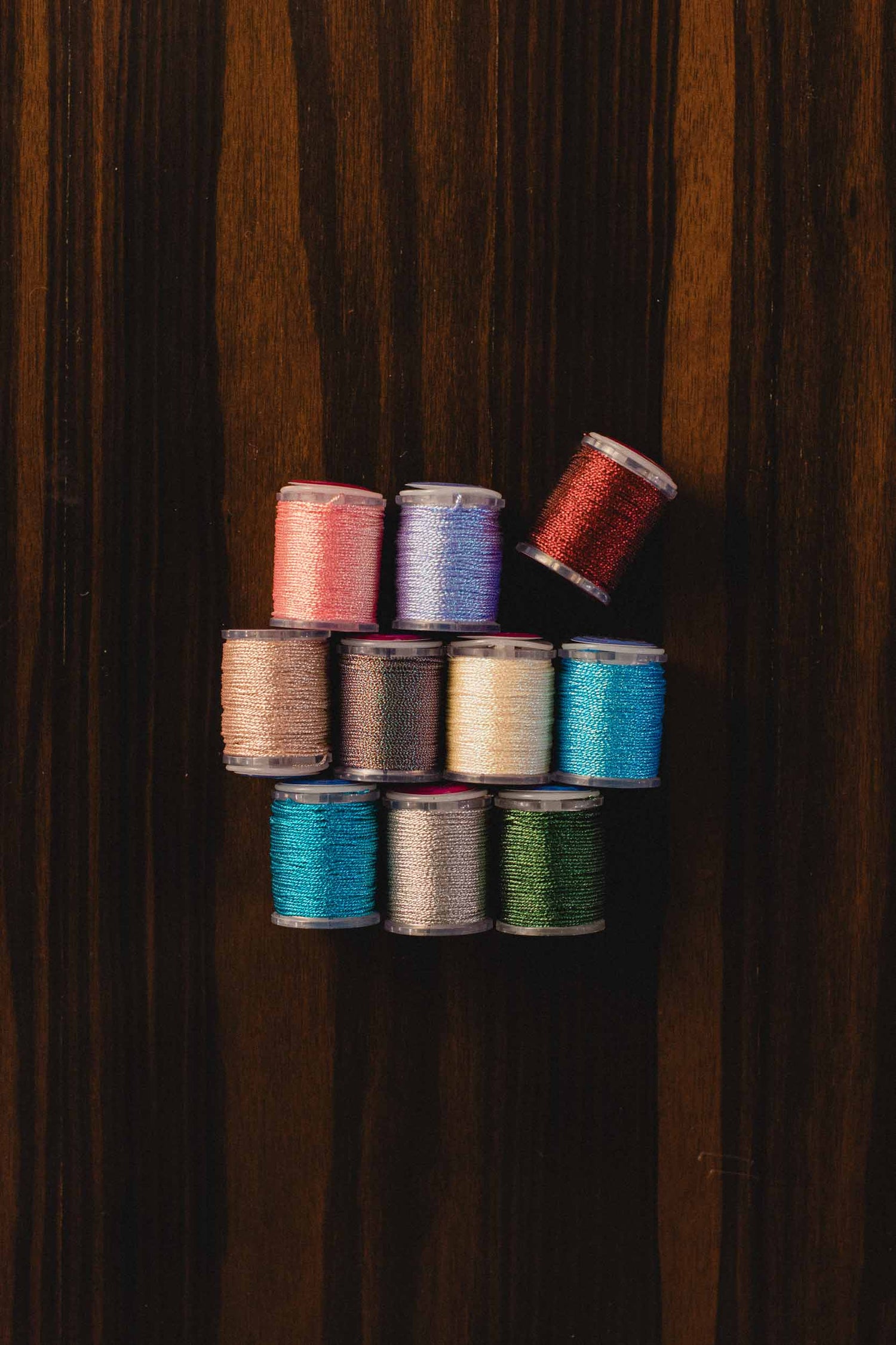 Assorted spools of thread on a wooden surface. | The Pepper Pot, Barrington, IL