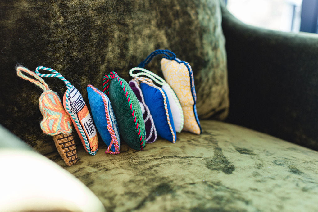Colorful needlepoint ornaments on a textured surface.  | The Pepper Pot Barrington, IL 
