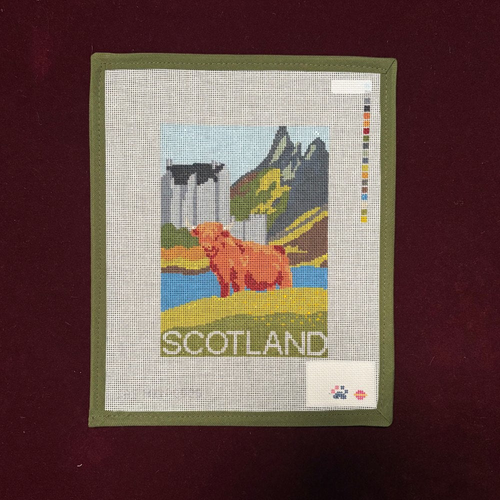 Needlepoint canvas with Scotland typography and a Scottish highland cow with a river and mountains on a red background