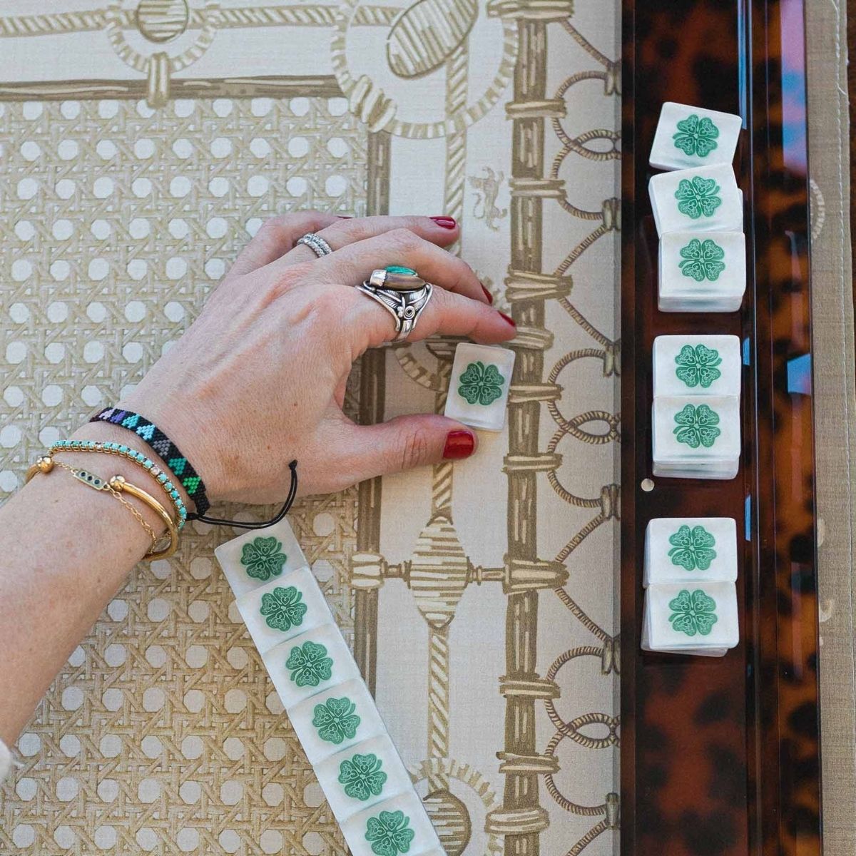 Hand applying green American Mahjong tiles with a floral design at The Pepper Pot in Barrington IL