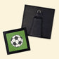 Completed soccer ball needlepoint project with a black frame for displaying